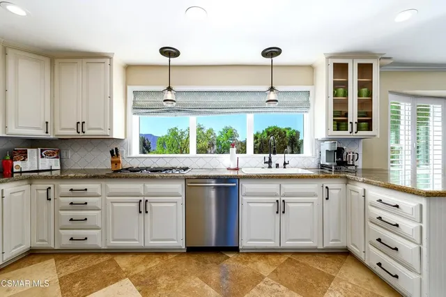 a kitchen with stainless steel appliances kitchen island granite countertop a refrigerator and a stove top oven
