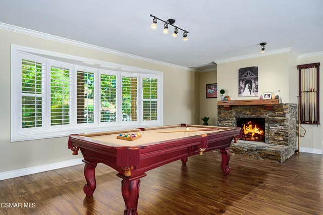 a living room with furniture a pool table and a large window