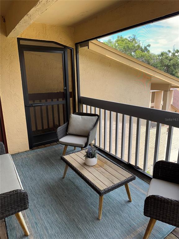 1550 South Belcher Road, Unit 335 Clearwater, FL 33764 - Photo 12 of 21 a balcony with wooden floor outdoor seating and wooden floor