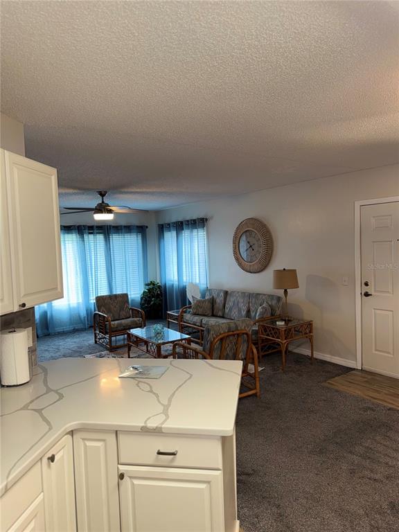 1550 South Belcher Road, Unit 335 Clearwater, FL 33764 - Photo 9 of 21 a kitchen with kitchen island granite countertop a sink and a stove next to a window