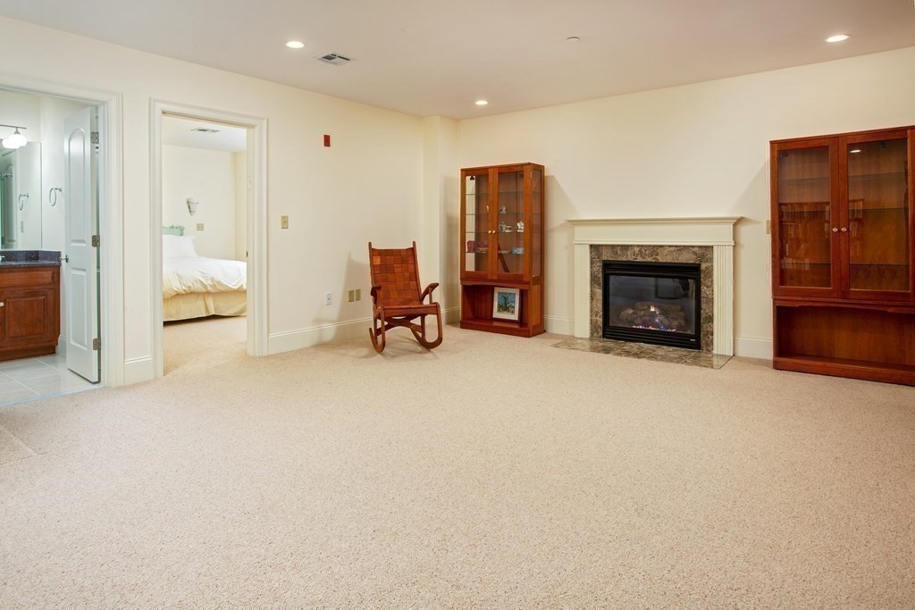 287 Langley Road, Unit 27 Newton, MA 02459 - Photo 12 of 17 an empty room with furniture and a fireplace