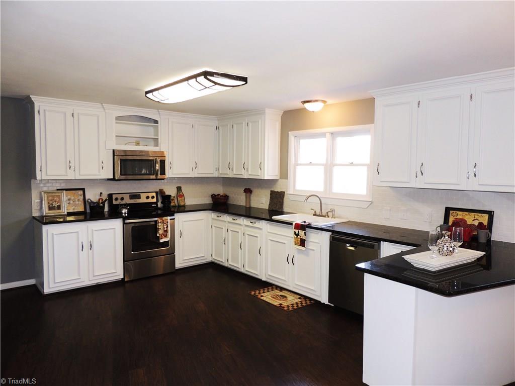 4017 Resthaven Road High Point, NC 27265 - Photo 9 of 29 Tons of counter and cabinet space in this well-planned kitchen! Kitchen is accented by tile back-splash!