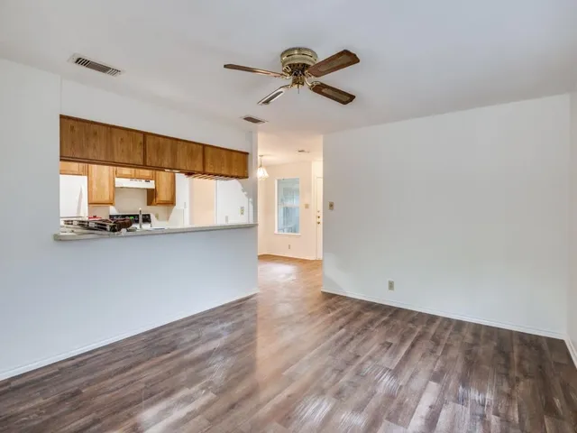 a view of a kitchen with wooden floor and a ceiling fan