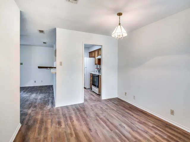 a view of a room with wooden floor closet and windows