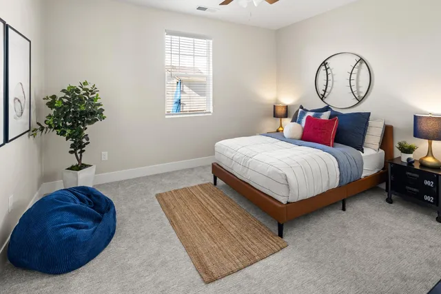 a bed room with a bed and a potted plant