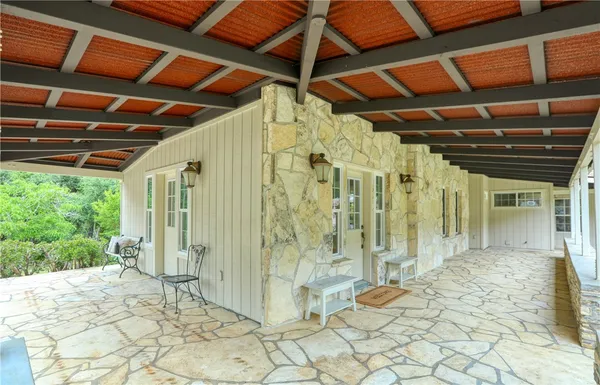 a view of a porch with a table and chairs