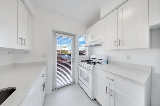 a kitchen with white cabinets and white appliances