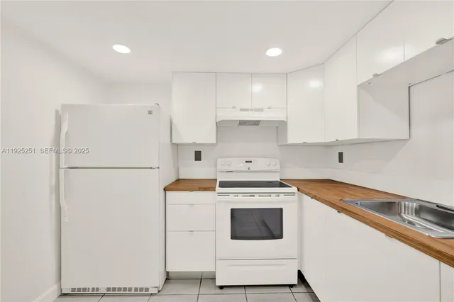 a kitchen with a white stove refrigerator and cabinets