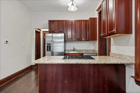 a kitchen with granite countertop a sink cabinets and stainless steel appliances