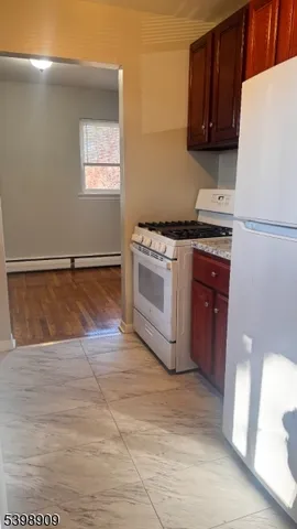 a kitchen with granite countertop a stove a sink and a refrigerator