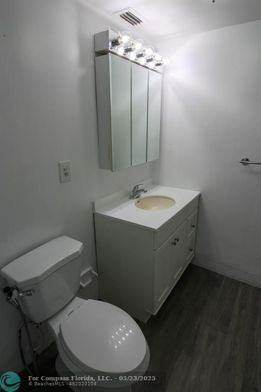 9159 Southwest 77th Avenue, Unit 411 Miami, FL 33156 - Photo 13 of 18 a bathroom with a granite countertop toilet sink and mirror