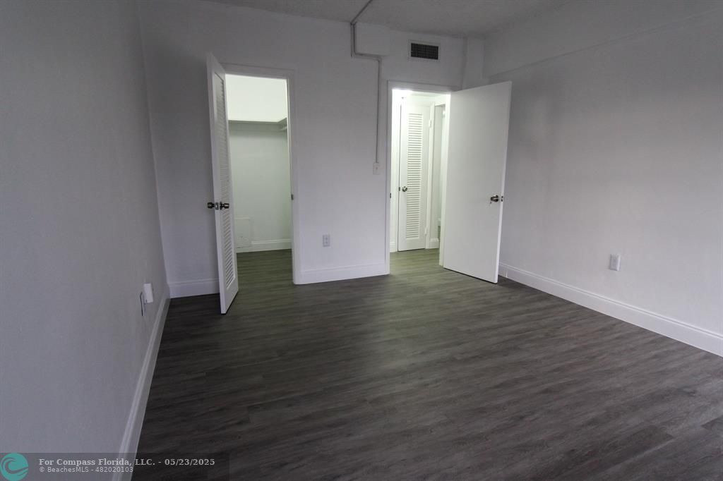 9159 Southwest 77th Avenue, Unit 411 Miami, FL 33156 - Photo 17 of 18 an empty room with wooden floor and windows