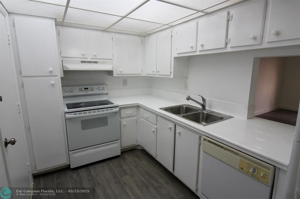 9159 Southwest 77th Avenue, Unit 411 Miami, FL 33156 - Photo 2 of 18 a kitchen with cabinets and white appliances