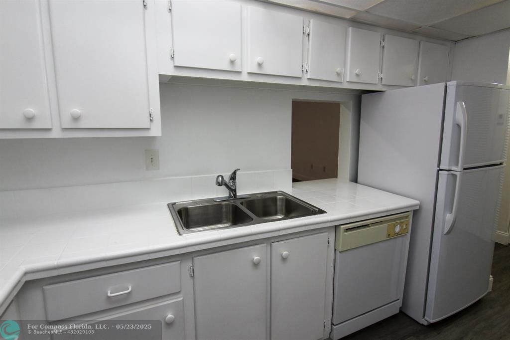 9159 Southwest 77th Avenue, Unit 411 Miami, FL 33156 - Photo 3 of 18 a kitchen with stainless steel appliances white cabinets and a refrigerator