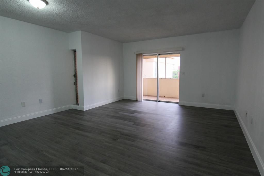 9159 Southwest 77th Avenue, Unit 411 Miami, FL 33156 - Photo 7 of 18 an empty room with wooden floor and windows