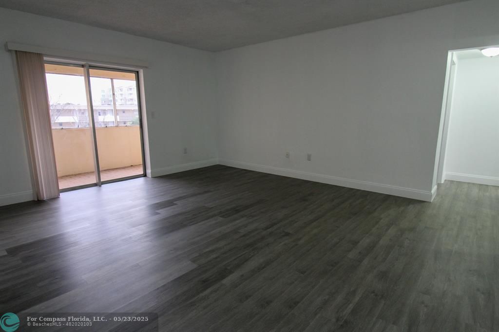 9159 Southwest 77th Avenue, Unit 411 Miami, FL 33156 - Photo 8 of 18 a view of an empty room with wooden floor and a window