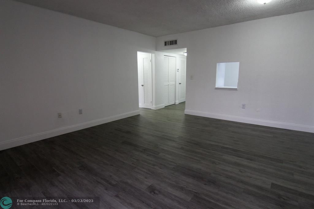 9159 Southwest 77th Avenue, Unit 411 Miami, FL 33156 - Photo 9 of 18 an empty room with wooden floor and windows