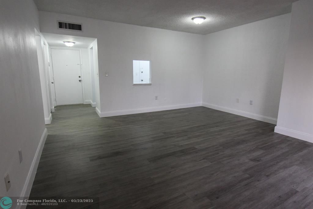 9159 Southwest 77th Avenue, Unit 411 Miami, FL 33156 - Photo 10 of 18 an empty room with wooden floor and windows