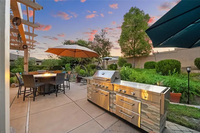 a view of a patio with a table and chairs under an umbrella