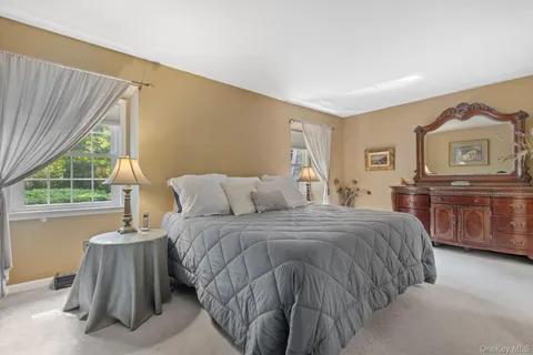 a spacious bedroom with a bed and a dresser