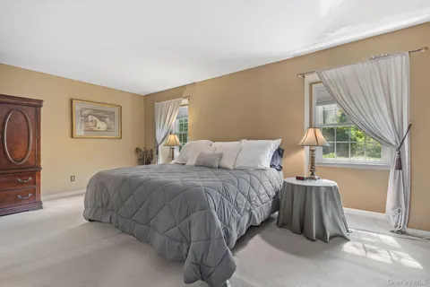 a spacious bedroom with a bed and large windows