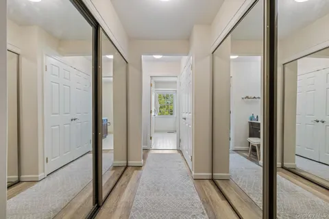 a view of a hallway with a glass door and furniture