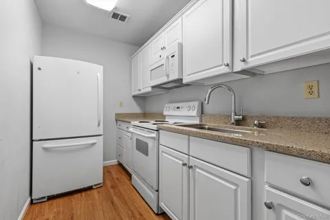 a kitchen with appliances a sink and cabinets