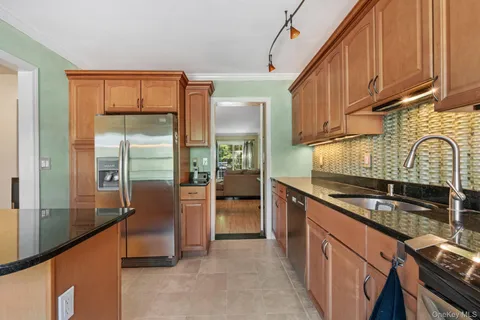 a kitchen with stainless steel appliances granite countertop a stove a sink and a refrigerator