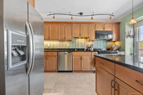 a kitchen with granite countertop a refrigerator and a sink