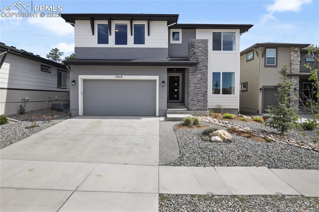 11848 Alydar Loop Colorado Springs, CO 80921 - Photo 2 of 50 View of front facade with stucco siding, concrete driveway, and an attached garage