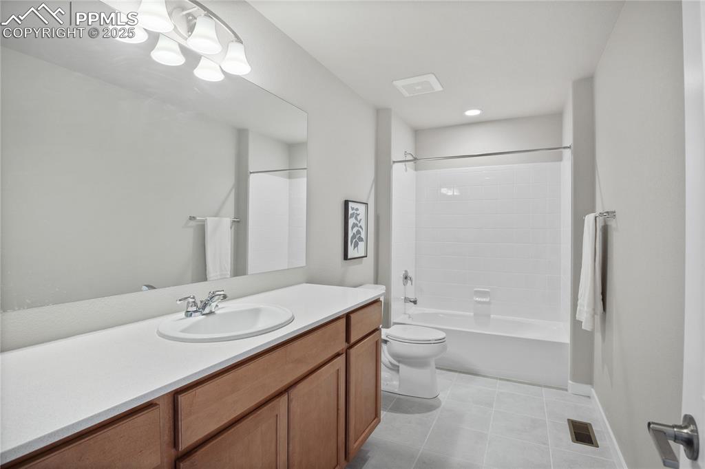 11848 Alydar Loop Colorado Springs, CO 80921 - Photo 23 of 50 Bathroom with tile patterned floors, toilet, vanity, and shower / tub combination