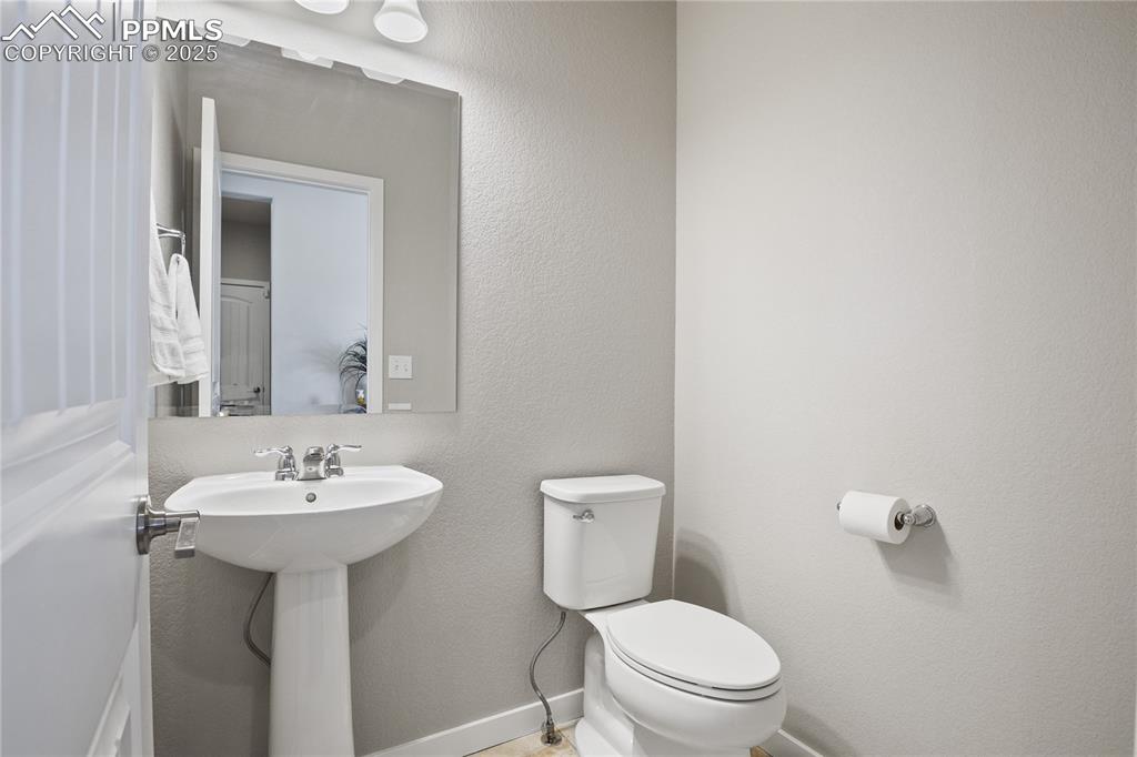 11848 Alydar Loop Colorado Springs, CO 80921 - Photo 38 of 50 Bathroom featuring toilet, a sink, and baseboards