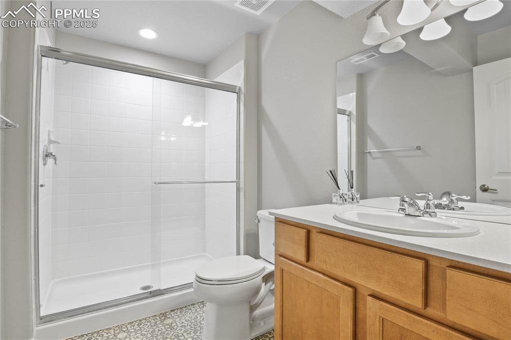 11848 Alydar Loop Colorado Springs, CO 80921 - Photo 41 of 50 Full bathroom featuring a shower stall, toilet, vanity, and recessed lighting