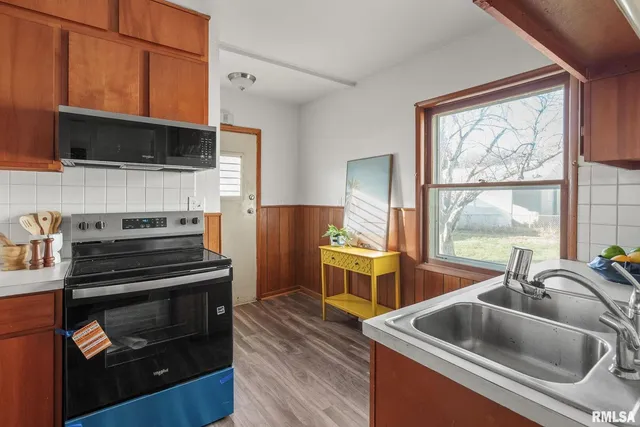 a kitchen with a stove a sink and a microwave