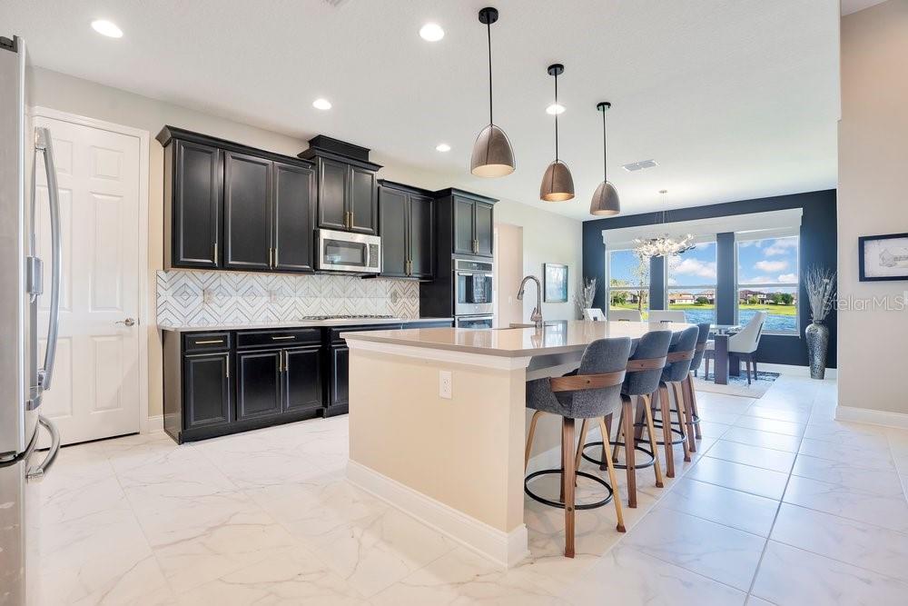 805 Riviera Bella Drive DeBary, FL 32713 - Photo 18 of 86 a large kitchen with a large counter top space a sink stainless steel appliances and cabinets