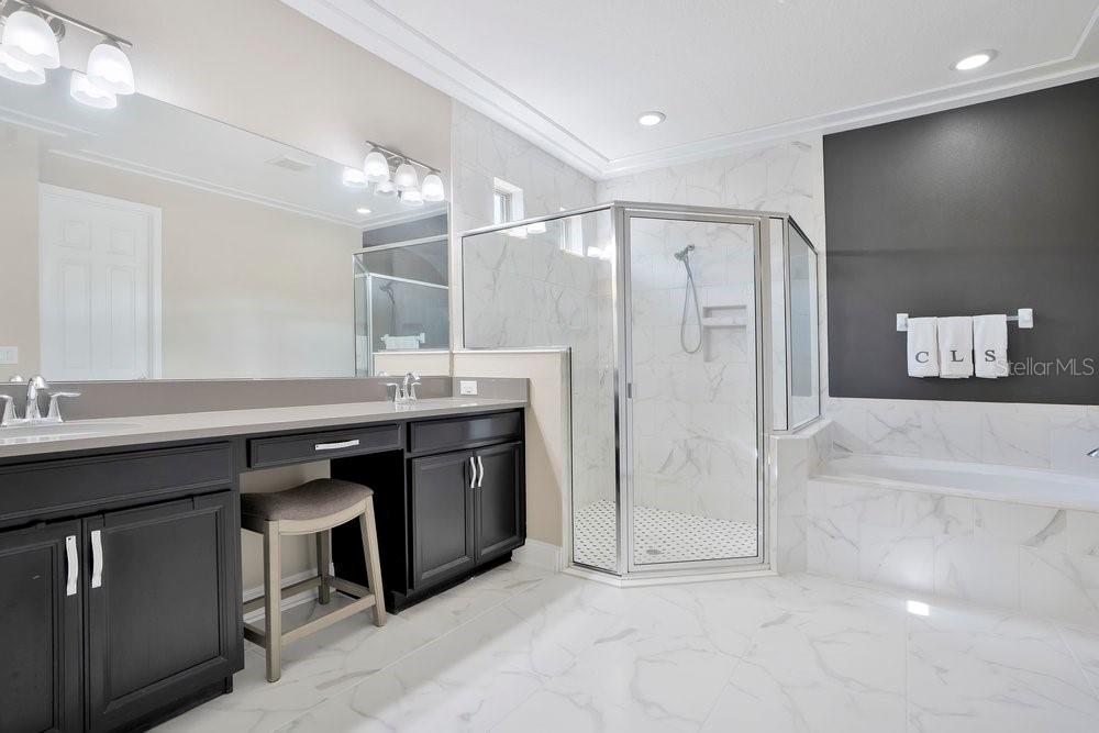 805 Riviera Bella Drive DeBary, FL 32713 - Photo 39 of 86 a bathroom with a double vanity sink a large mirror and a bathtub