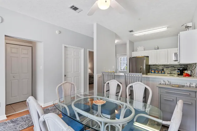 a kitchen with a dining table chairs and refrigerator
