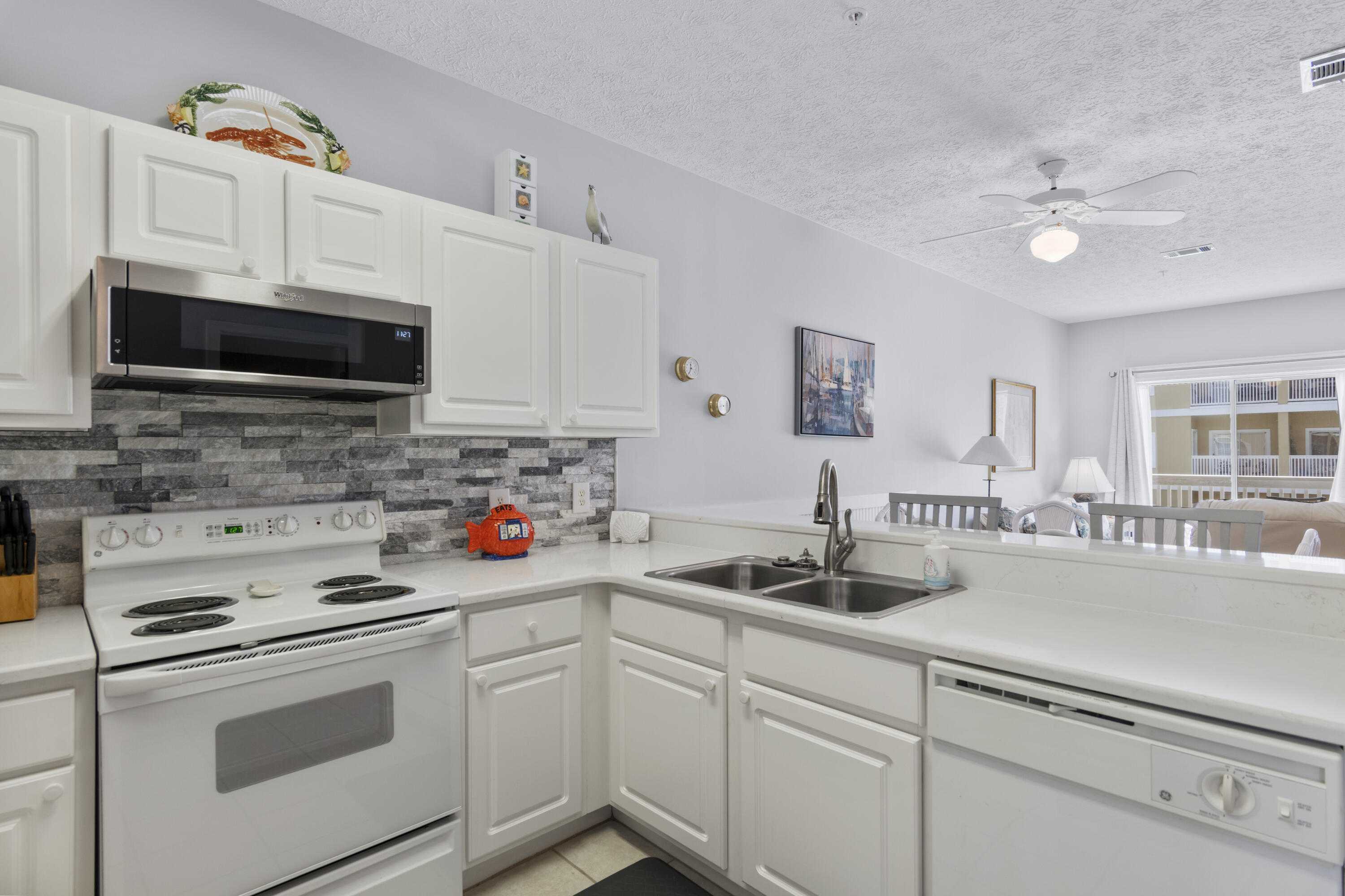 34 Heron's Watch Way, Unit 2202 Santa Rosa Beach, FL 32459 - Photo 14 of 29 a kitchen with stainless steel appliances granite countertop white cabinets a stove a sink and dishwasher