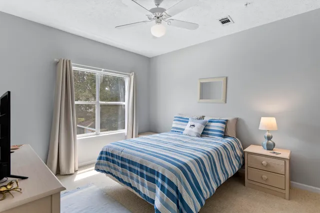 a bedroom with a bed and a flat tv screen on the dresser