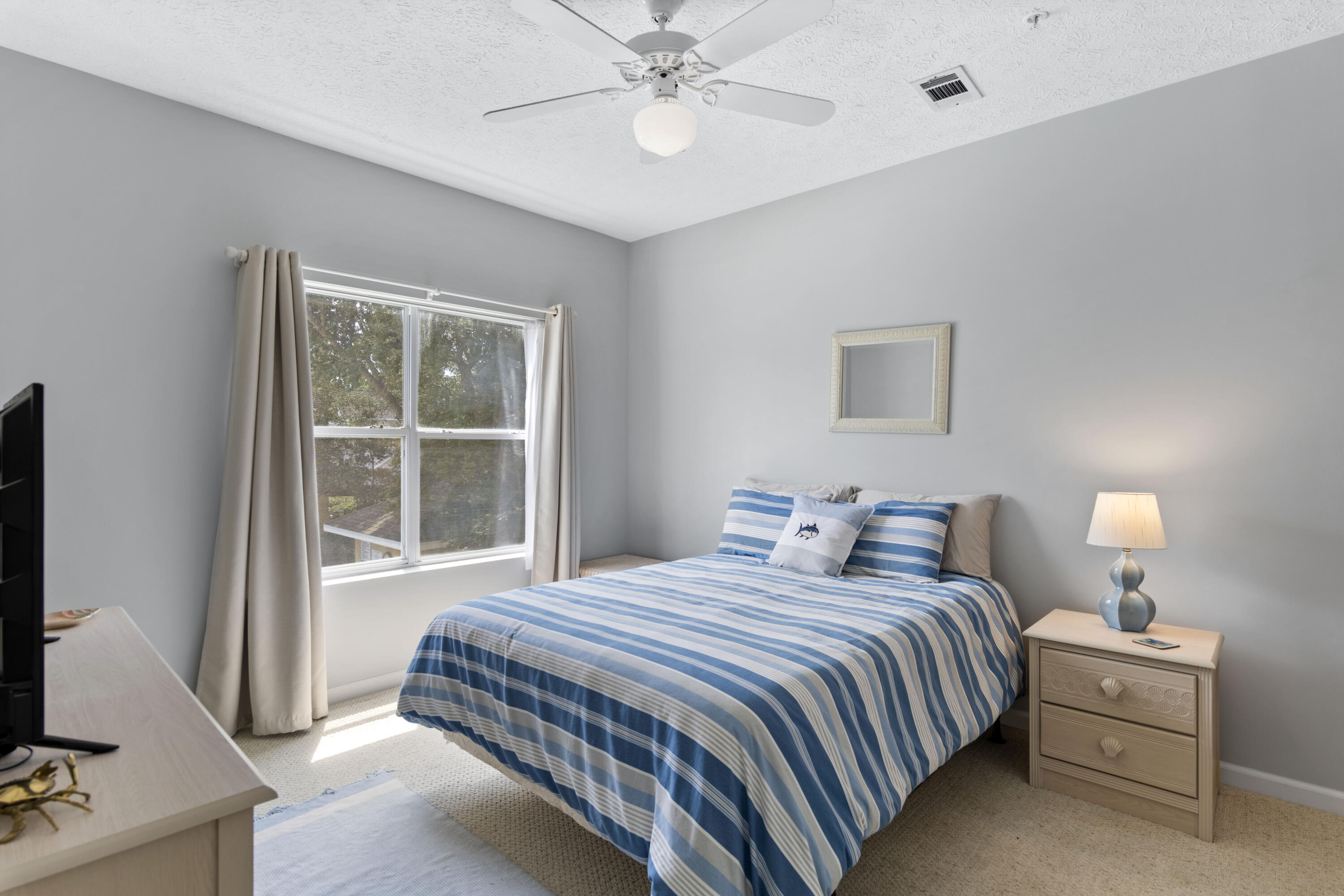 34 Heron's Watch Way, Unit 2202 Santa Rosa Beach, FL 32459 - Photo 16 of 29 a bedroom with a bed and a flat tv screen on the dresser