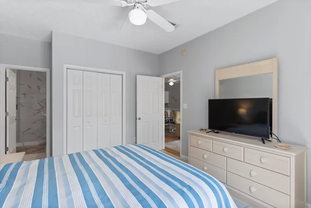 a bedroom with a bed and a flat tv screen on dresser