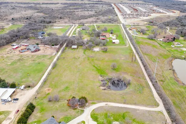 a view of a house with a big yard and large tree