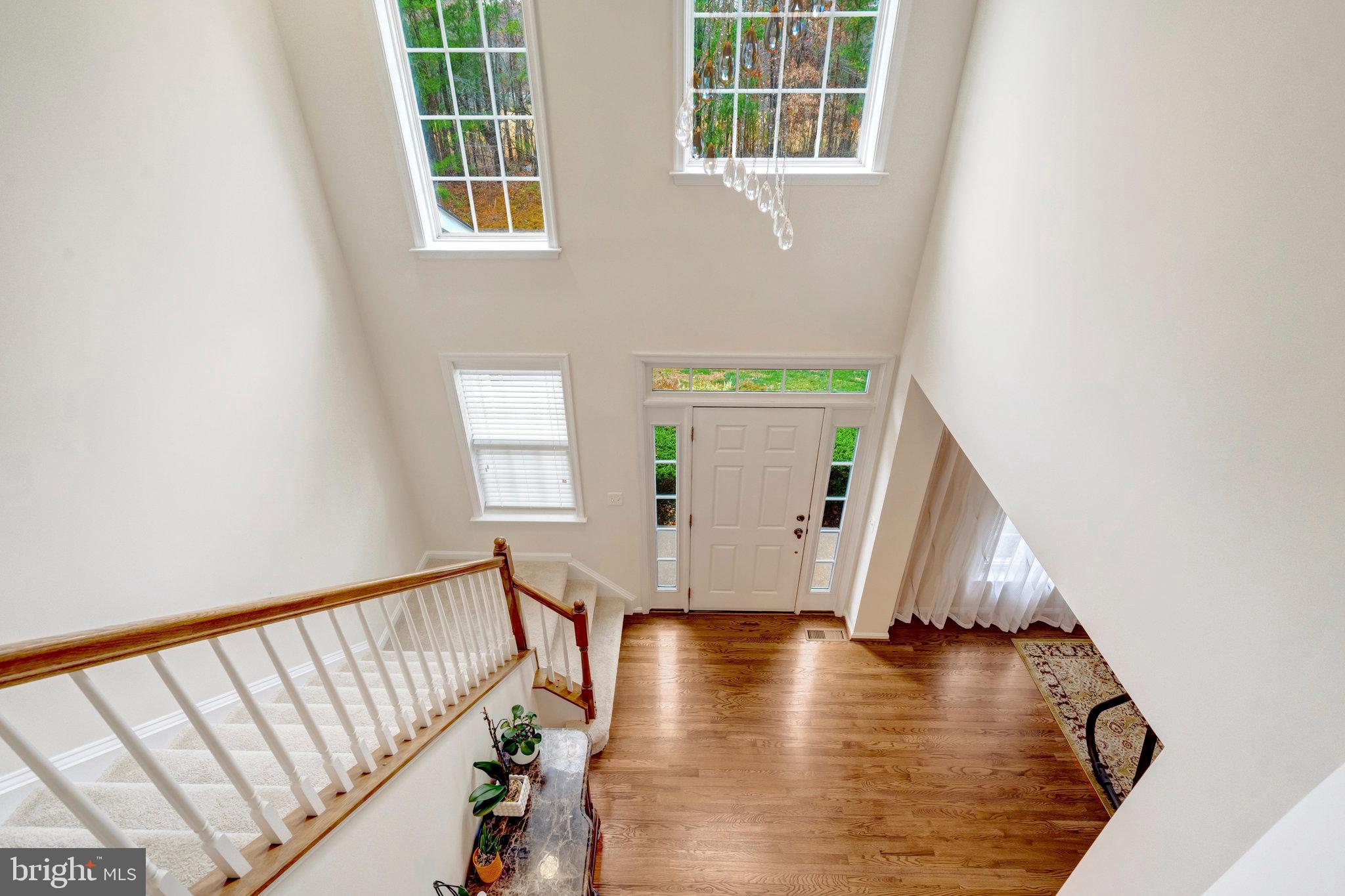 7726 Yalta Way Gainesville, VA 20155 - Photo 37 of 75 a view of a hallway with wooden floor and staircase