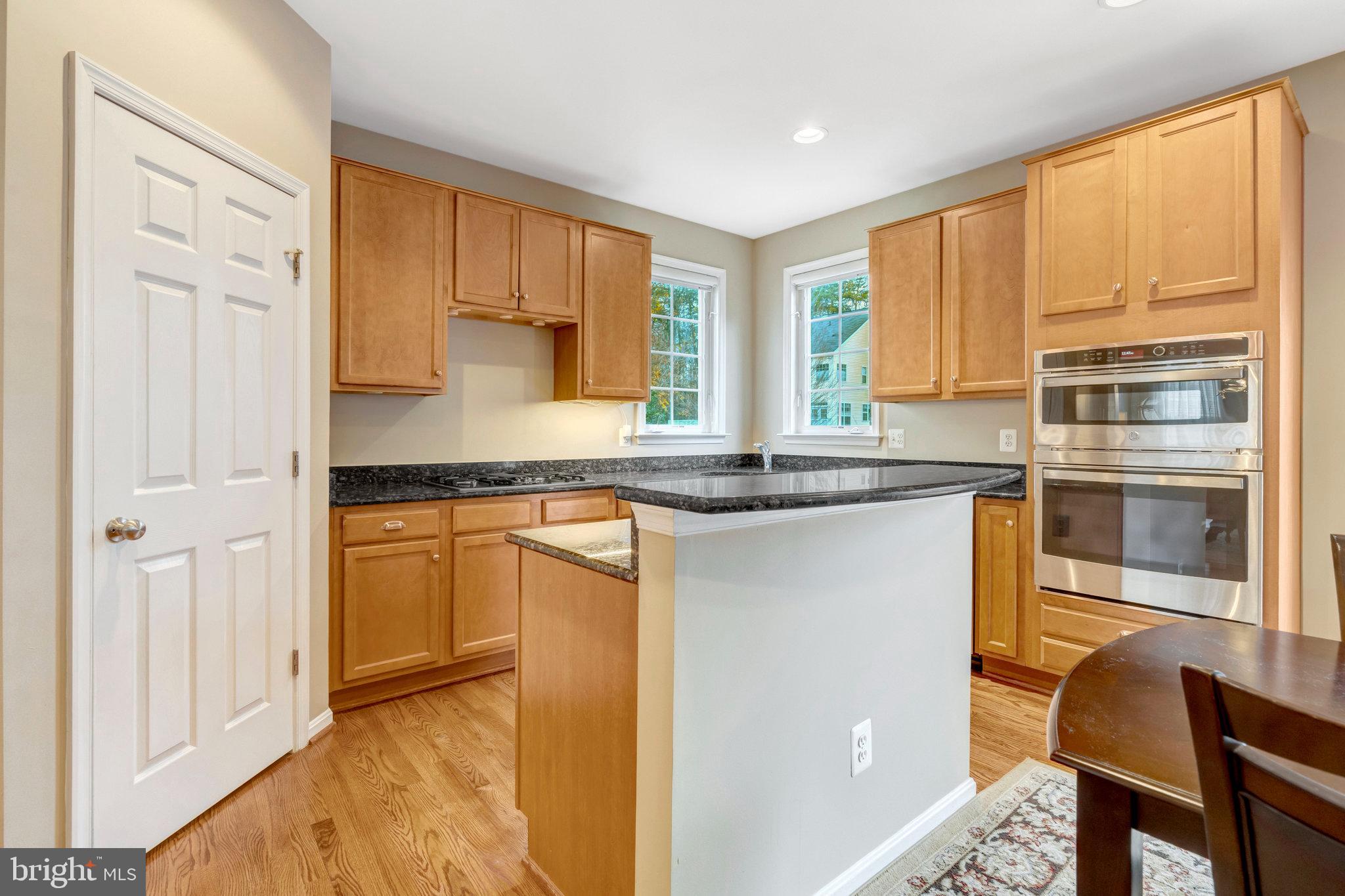 7726 Yalta Way Gainesville, VA 20155 - Photo 4 of 75 a kitchen with stainless steel appliances granite countertop a refrigerator and a stove top oven