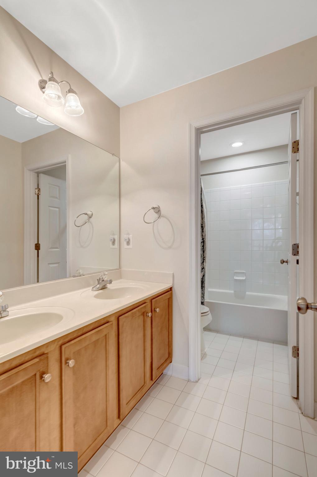 7726 Yalta Way Gainesville, VA 20155 - Photo 43 of 75 a spacious bathroom with a granite countertop sink a toilet a mirror and bathtub