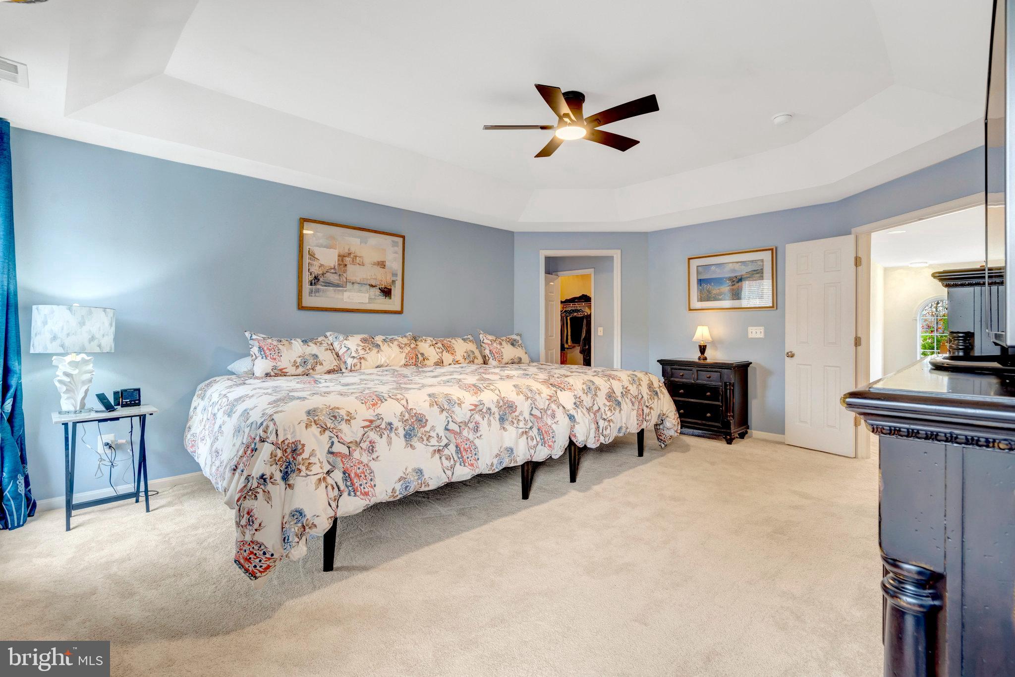 7726 Yalta Way Gainesville, VA 20155 - Photo 51 of 75 a spacious bedroom with a bed and a chandelier