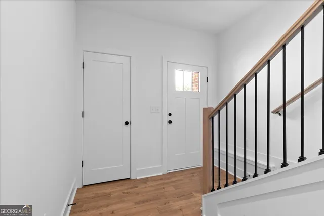 a view of a hallway with wooden floor and entryway
