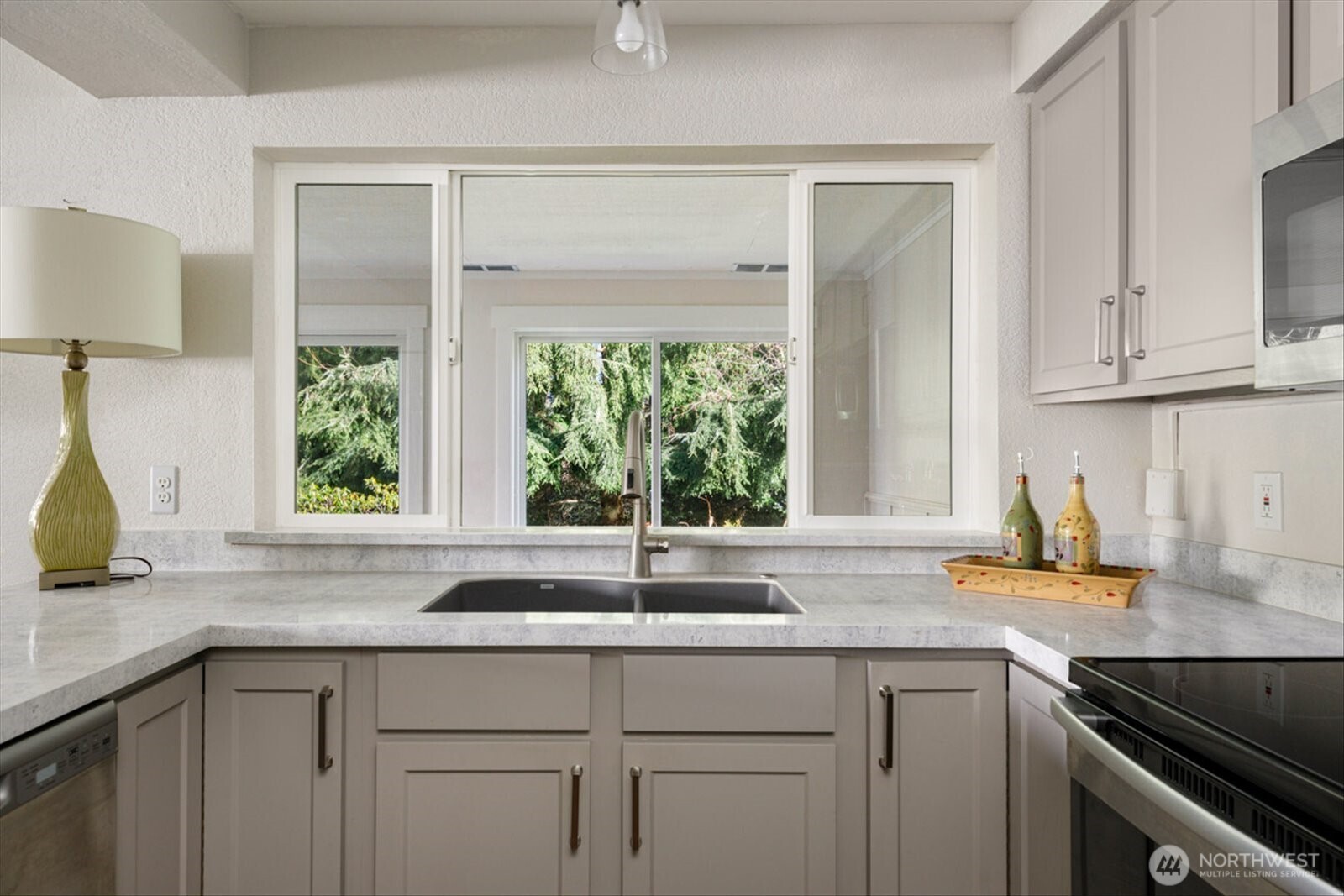 566 Creekside Terrace, Unit 101 Langley, WA 98260 - Photo 4 of 31 a kitchen with stainless steel appliances white cabinets a window and a sink