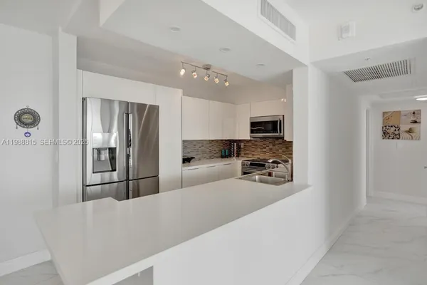 a kitchen with stainless steel appliances a refrigerator and a stove top oven