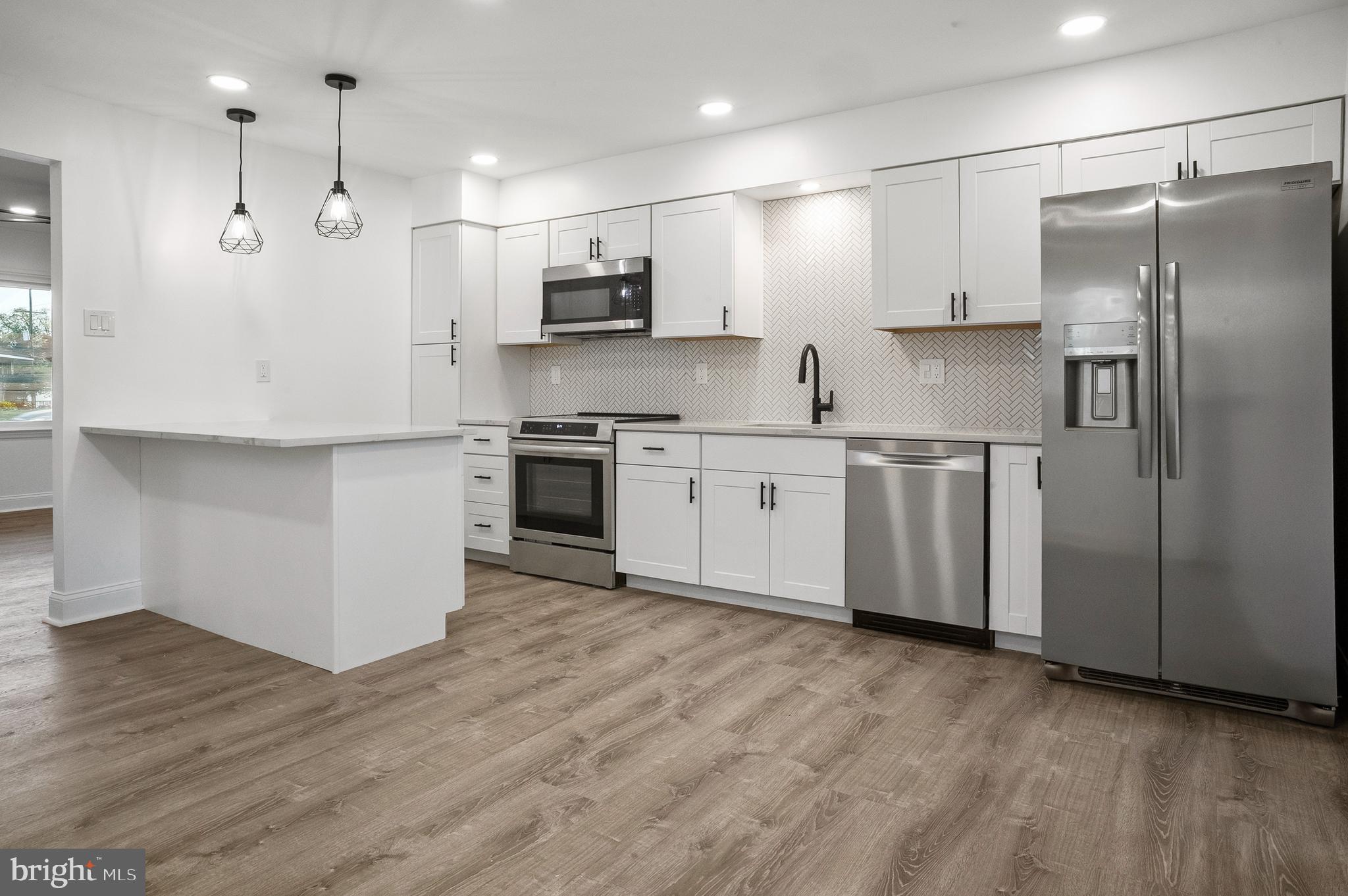 601 Evesham Avenue West Magnolia, NJ 08049 - Photo 7 of 20 a large kitchen with stainless steel appliances granite countertop a stove a sink and a refrigerator
